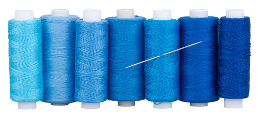 Many spools with blue thread and needle for sewing, supply for sewing, isolated objects 
