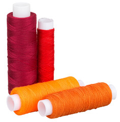 Group of spools with red and orange thread and for sewing, supply for sewing, isolated objects 
