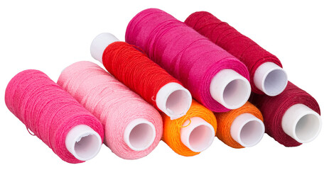 Many spools with pink red purple orange thread for sewing, supply for sewing, isolated objects 
