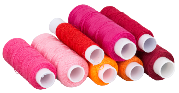 Many spools with pink red purple orange thread for sewing, supply for sewing, isolated objects 
