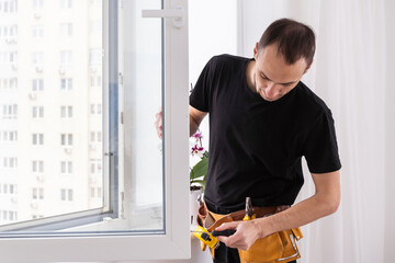 Worker adjusting installed window with screwdriver indoors, closeup