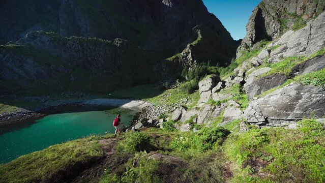 Lone Woman Trek With Her Pet Dog On Towering Coastal Mountains In Lovund, Norway. Wide Shot