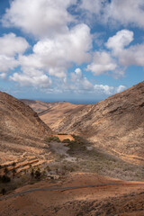 Paisaje desértico y volcánico con grandes montañas en el Mirador Risco de la Peña en Fuerteventura Islas Canarias en un día soleado con cielo azul y algunas nubes en Islas Canarias