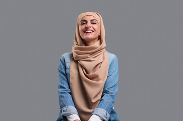 Young woman in beige hijab looking cute and smiling
