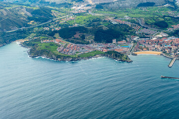 aerial of village Castro Urdiales with 2 piers and sandy beach in Cantabria,
