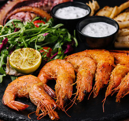 Traditional greek grilled seafood on restaurant wooden plate