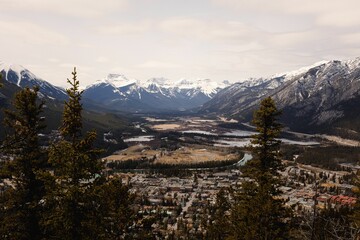 Aerial shot over the town Banff in Alberta Canada surrounded by snowy mountains