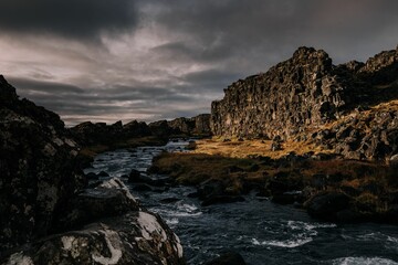 Beautiful landscapes of Iceland with river streams against rocky cliffs in a cloudy weather