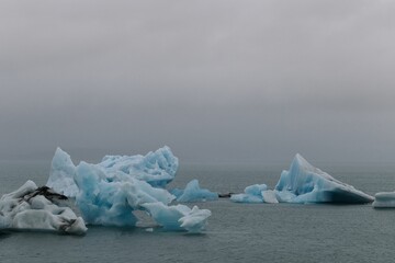Beautiful view of icebergs in an ocean in a cloudy weather