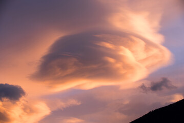 uno splendido tramonto in montagna con nuvole di forma particolare ed arancioni intense