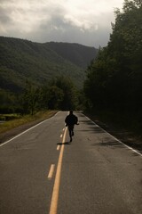 Obraz premium a man is going down a street in the mountains on a cloudy day