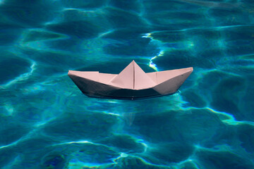 Paper boat on the sea background. Tourism, travel dreams vacation holiday. Cruise ship concept. Origami paper sailing boat.