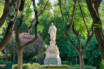 Papier Peint photo Monument historique Scenic view of a white sculpture of a greek man standing in a park surrounded by nature