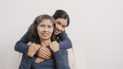 Obraz premium love, warmth, encouragement, Mother's day concept, young adult female daughter congratulate excited asian elderly mother at sofa with birthday anniversary, two generations family photo, real people.