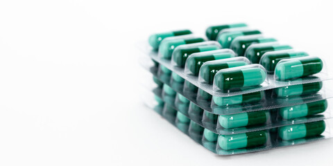 Green pills in plastic package. Global healthcare and pharmaceutical industry concept.