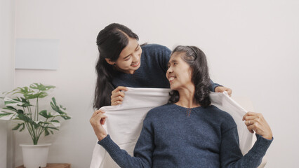Also cover the blanket, blanket, Mother's day concept, young adult female daughter congratulate excited asian elderly mother at sofa with birthday anniversary, two generations family, real people.