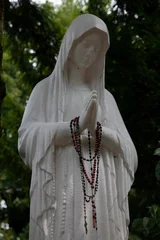 Papier Peint photo autocollant Monument historique Statue of a woman in graveyard, grieving and praying with prayer beads on her hands