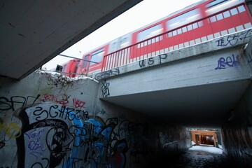 Tunnel with graffiti walls under a fast-moving train at Diebsteich station in Hamburg, Germany