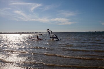 Naklejka premium Surfers on the surface of a wavy sea in a sunny day