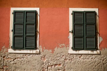 Venice red terracotta textured wall with green shutters