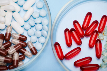 Flat lay. Close-up of various pharmaceutical pills and gel capsules with granules and fat-soluble...
