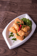 vegan deep fried golden beancurd tofu in salted egg yolk curry leaf pumpkin cream chilli vegetable on wood table asian chinese appetiser snack banquet halal food menu for restaurant