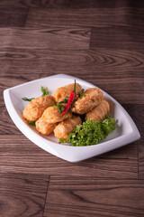 vegan deep fried golden beancurd tofu in salted egg yolk curry leaf pumpkin cream chilli vegetable on wood table asian chinese appetiser snack banquet halal food menu for restaurant