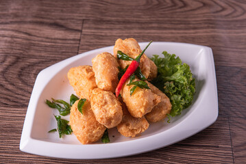 vegan deep fried golden beancurd tofu in salted egg yolk curry leaf pumpkin cream chilli vegetable on wood table asian chinese appetiser snack banquet halal food menu for restaurant
