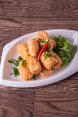 vegan deep fried golden beancurd tofu in salted egg yolk curry leaf pumpkin cream chilli vegetable on wood table asian chinese appetiser snack banquet halal food menu for restaurant