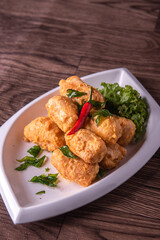 vegan deep fried golden beancurd tofu in salted egg yolk curry leaf pumpkin cream chilli vegetable on wood table asian chinese appetiser snack banquet halal food menu for restaurant