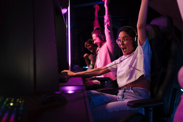 Team of gamers celebrating victory while playing online video game on tournament in cybersport club