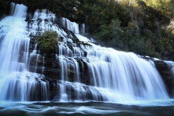 Landscape of a beautiful waterfall surrounded by rocks in a forest