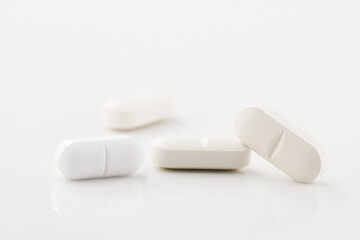 Medical pills close up. White pills, white background. Concept of healthcare and medicine.