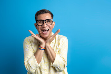 Man with eyeglasses and a shirt wearing a rainbow bracelet