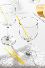 Empty glasses and lemon on a white table
