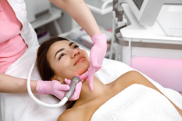 Obraz na płótnie Canvas Facial treatment, Rejuvenating facials,Hydro-microdermabrasion,Skin therapy,Rejuvenation treatment,cosmetology procedure. The aesthetician is giving the woman a facial at the spa