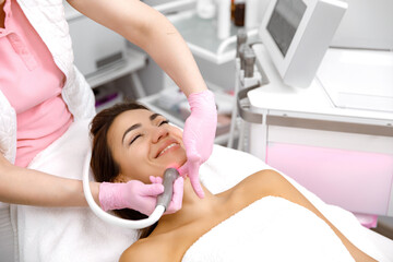 Obraz na płótnie Canvas Facial treatment, Hydro-microdermabrasion, Skin therapy, Cosmetology service, Facial treatment, esthetic procedure, Rejuvenation treatment. woman is undergoing a facial procedure at a cosmetology