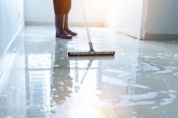 Janitor squeegee water on the floor hallway office building or walkway after school and classroom...