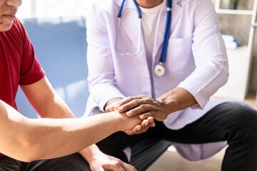 Obraz premium A young man consulted a doctor With a wrist injury in the office at the doctor's desk Male doctor examined the wrist for patient at the hospital.