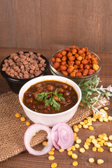 Chole masala or chana indian vegan food made of cooked chickpeas, tomatoes and cumin decorated with onion rings.