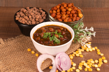 Chole masala or chana indian vegan food made of cooked chickpeas, tomatoes and cumin decorated with onion rings.