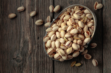 Salted pistachios on an old wooden table.