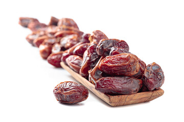 Dates in a wooden dish isolated on a white background.