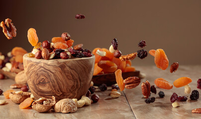 The mix of nuts and raisins in a wooden bowl.