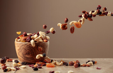 The mix of nuts and raisins in a wooden bowl.