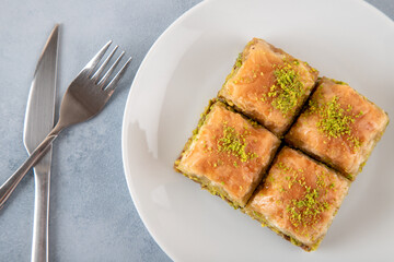 Pistachio Turkish baklava on a white plate.Close-up of four slices of baklava
