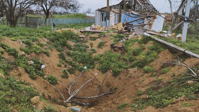 War crime. Civil houses shot down by air bomb fab-500. A huge bomb crater next to a civilian house in Ukrainian village at Kherson region is completely destroyed by the Russians in 2022, exact date