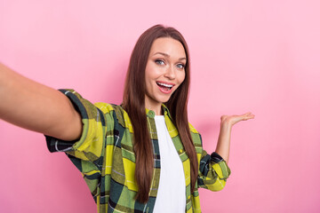 Portrait of optimistic good mood girl straight hairdo plaid shirt doing selfie demonstrate product isolated on pink color background