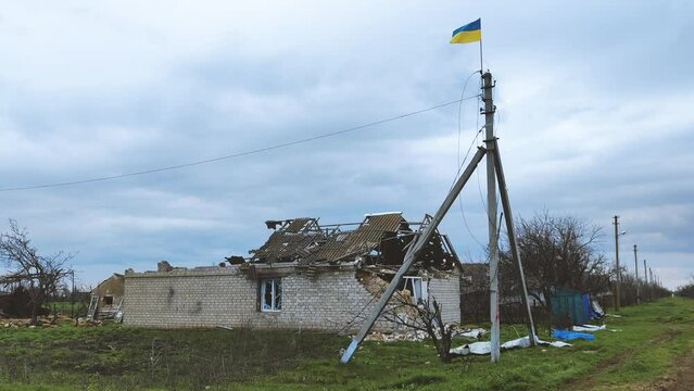 War crime. Civil houses with Ukrainian flag shot down by tanks and destroyed by artillery by Russian occupiers. Ukrainian village in the Kherson region is completely destroyed by the Russians in 2022