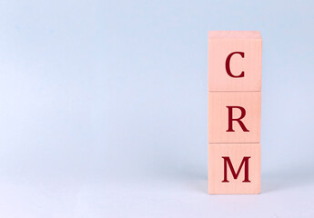 CRM on wooden cubes on a blue background